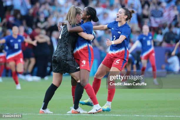 Alyssa Naeher hugs Naomi Girma as the USWNT takes Olympic soccer gold.