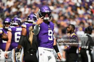 JJ McCarthy of the Minnesota Vikings communicates with head coach Kevin O'Connell in between plays during the preseason game against the raiders.