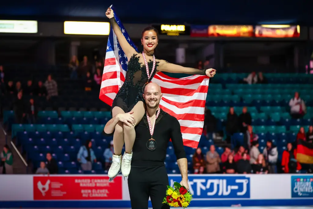 Nov 1, 2025; Saskatoon, SK, Canada; Ellie Kam and Danny O'Shea (USA) take the podium during the 2025 Skate Canada International at SaskTel Centre. Mandatory Credit: Sergei Belski-Imagn Images