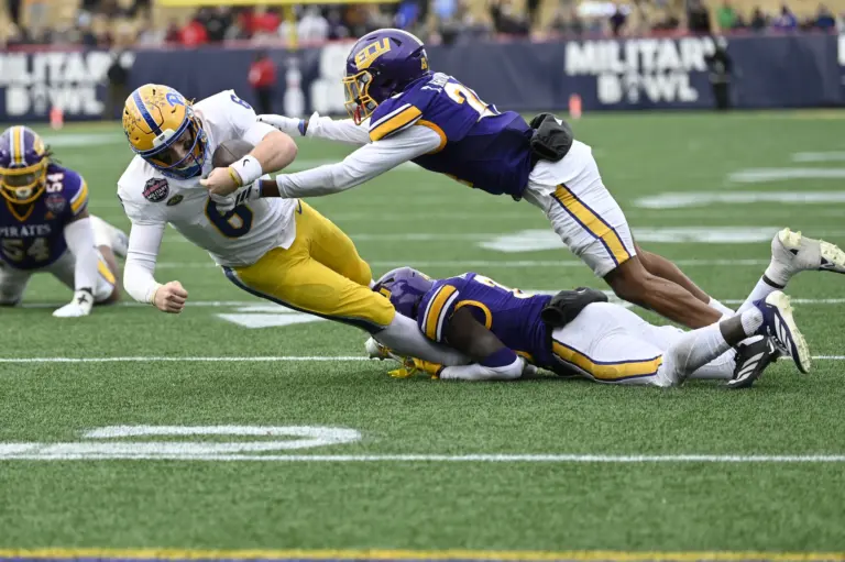 Dec 27, 2025; Annapolis, MD, USA; East Carolina Pirates defensive back Tymir Brown (24) and East Carolina Pirates defensive back Kamaurri McKinley (20) tackle Pittsburgh Panthers quarterback Mason Heintschel (6) on the two yard line during the fourth quarter of the Military Bowl at Navy-Marine Corps Stadium. Mandatory Credit: Tommy Gilligan-Imagn Images