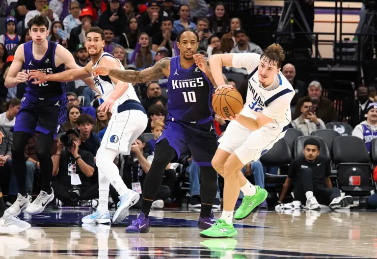 Dec 27, 2025; Sacramento, California, USA; Dallas Mavericks forward/guard Cooper Glagg (32) looks to pass the ball against Sacramento Kings forward/guard DeMar DeRozan (10) during the fourth quarter at Golden 1 Center. Mandatory Credit: Kelley L Cox-Imagn Images