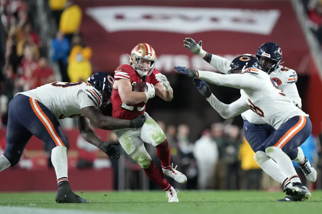 Christian McCaffery running through a couple of Bears players.