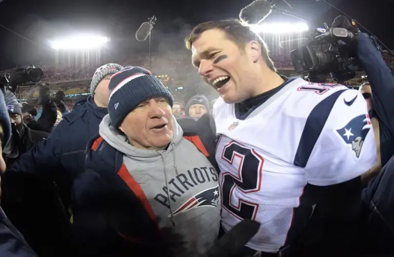 New England Patriots quarterback Tom Brady (12) celebrates with coach Bill Belichick after the AFC Championship game against the Kansas City Chiefs at Arrowhead Stadium