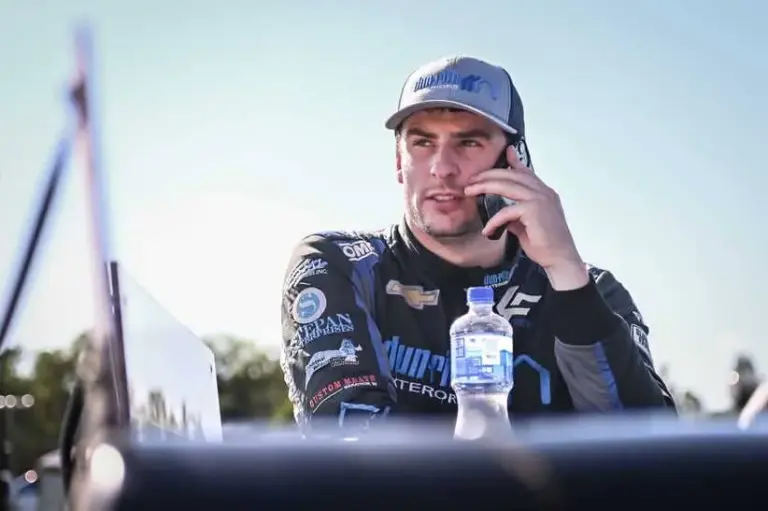 Luke Fenhaus (4) talks on the phone in the pits during qualifying at the Gandrud Auto Group 250 on Tuesday, August 6, 2024, at Wisconsin International Raceway in Kaukauna, Wisconsin.
