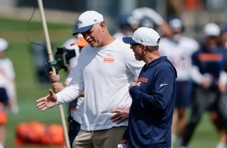 Denver Broncos offensive coordinator Joe Lombardi (L) and offensive assistant Pete Carmichael (R) during Denver Broncos Training Camp