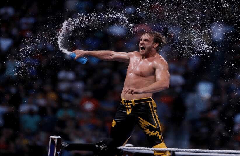 Logan Paul celebrates inside a WWE ring.