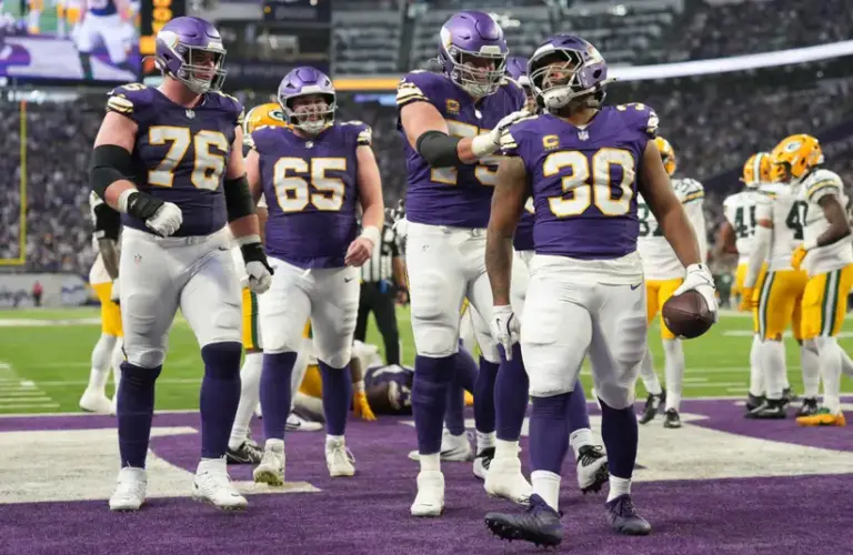 Vikings team in endzone celebrating a touchdown.