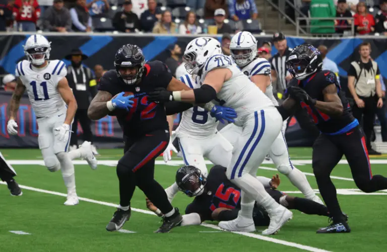 Colts player try to tackle Texan after fumble.