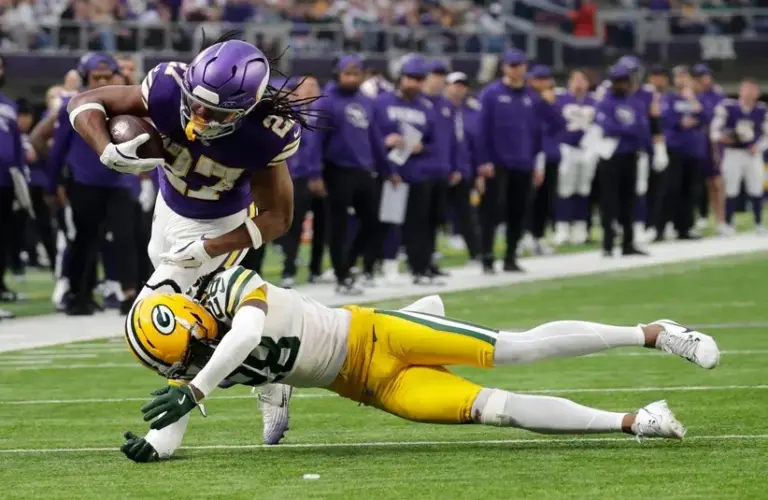 Green Bay Packers Trevon Diggs (28) puts a hit on Minnesota Vikings running back Jordan Mason (27) during their game Sunday, Jan. 4, 2026, at U.S. Bank Stadium in Minneapolis, Minnesota.