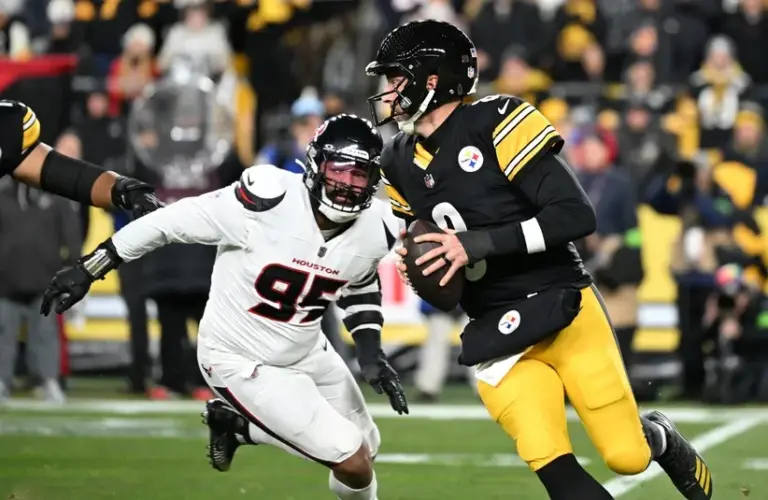 Pittsburgh Steelers quarterback Aaron Rodgers (8) scrambles from Houston Texans defensive end Derek Barnett (95) during the first half of an AFC Wild Card Round game at Acrisure Stadium.