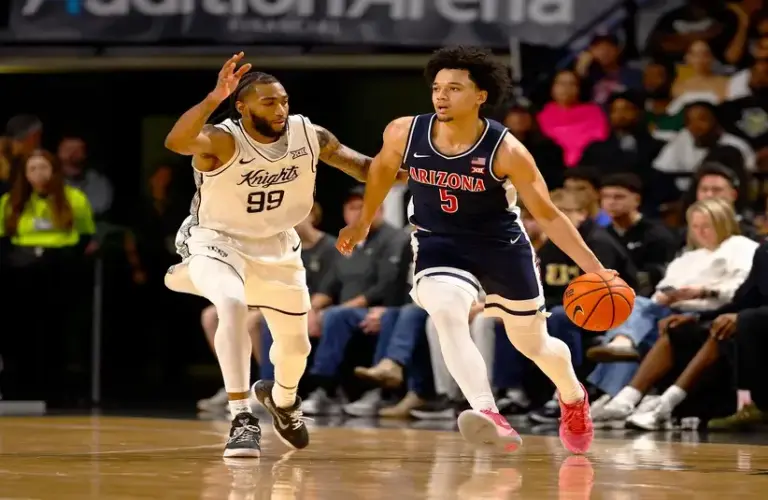 Arizona Wildcats guard Brayden Burries (5) dribbles around Central Florida Knights forward Jordan Burks (99) in the first half