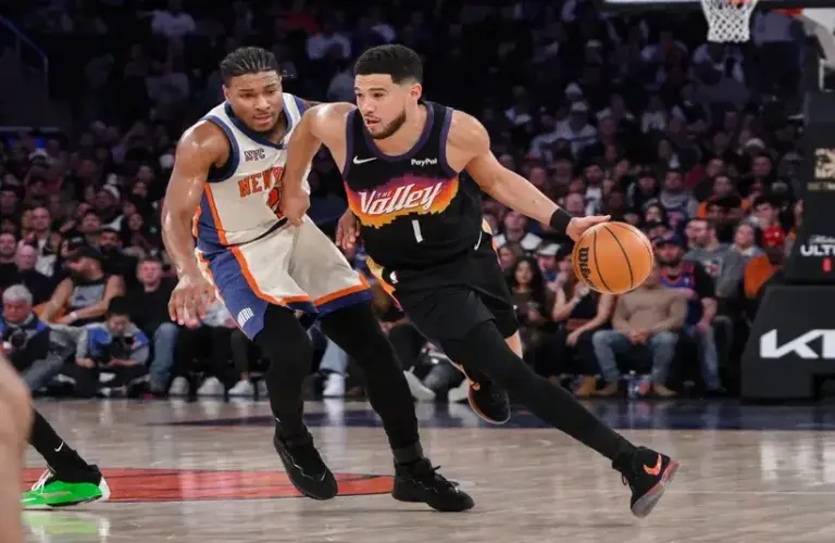 Phoenix Suns guard Devin Booker (1) brings the ball up court while defended by New York Knicks guard Miles McBride (2) during the second half