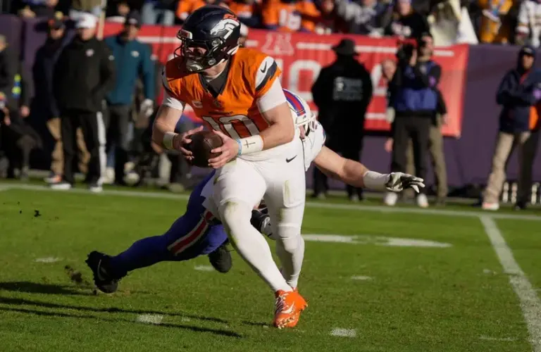 Denver Broncos Quarterback Bo Nix avoids Buffalo Bills Defensive End Joey Bosa.