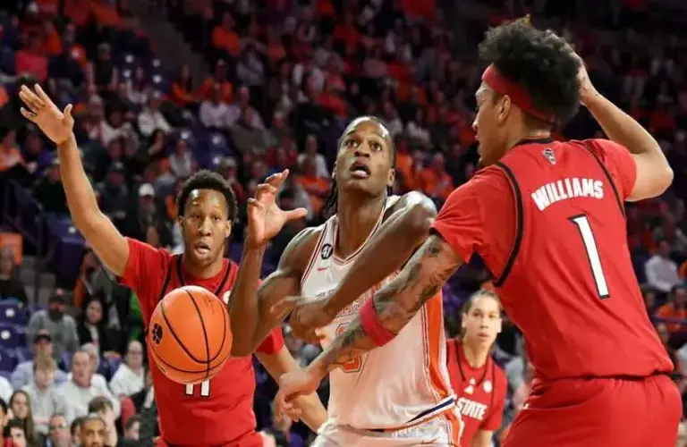 NC State Wolfpack guard Quadir Copeland (11) and NC State Wolfpack forward Darrion Williams (1) defend Clemson Tigers forward RJ Godfrey (0) in the first half