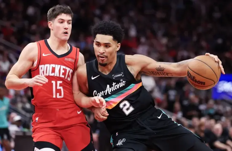 ;San Antonio Spurs guard Dylan Harper (2) dribbles against Houston Rockets guard Reed Sheppard (15) in the second half at Toyota Center