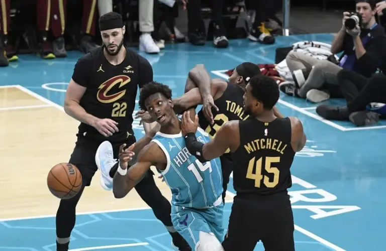 Charlotte Hornets center Moussa Diabate (14), Cleveland Cavaliers guard Donovan Mitchell and forward Nae’Qwan Tomlin (35) fight for a rebound during the first half at the Spectrum Center.