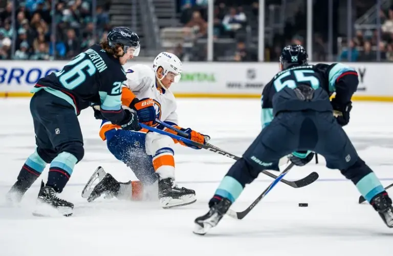 New York Islanders forward Maxim Tsyplakov (7) basttles Seattle Kraken forward Ryan Winterton (26), left, and defenseman Ryan Lindgren (55) for the puck during the third period at Climate Pledge Arena.