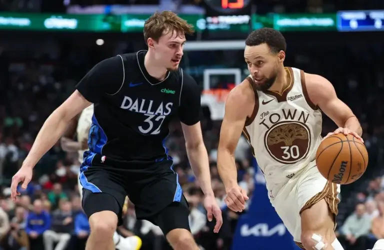 Golden State Warriors guard Stephen Curry (30) drives to the basket as Dallas Mavericks forward Cooper Flagg (32) defends during the first half at American Airlines Center