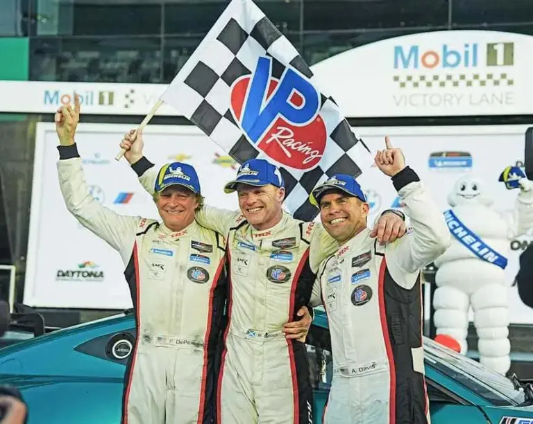 Frank DePew, Robin Liddell and Andrew Davis pose for photographers in Victory Lane after Rebel Rock Racing’s won the BMW M Endurance Challenge, Friday, Jan. 23, 2026.
