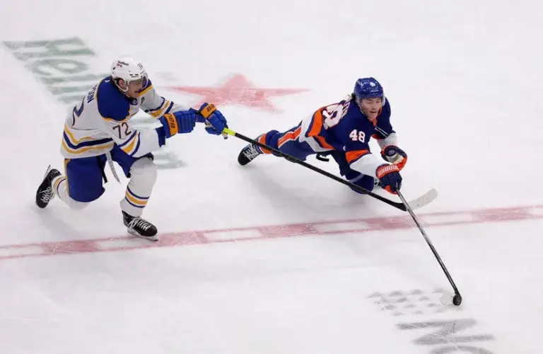 New York Islanders defenseman Matthew Schaefer (48) dives for the puck against Buffalo Sabres center Tage Thompson (72) during the third period at UBS Arena.