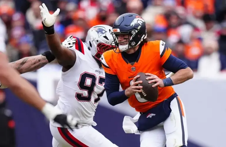 Denver Broncos quarterback Jarrett Stidham (8) drops back to pass against the New England Patriots during the first half in the 2026 AFC Championship Game at Empower Field at Mile High.
