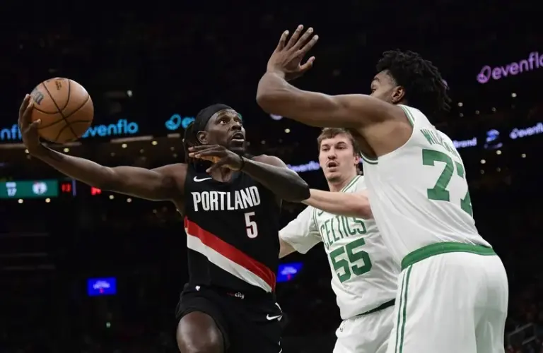 Portland Trail Blazers guard Jrue Holiday (5) shoots the ball while Boston Celtics forward Amari Williams (77) defends.