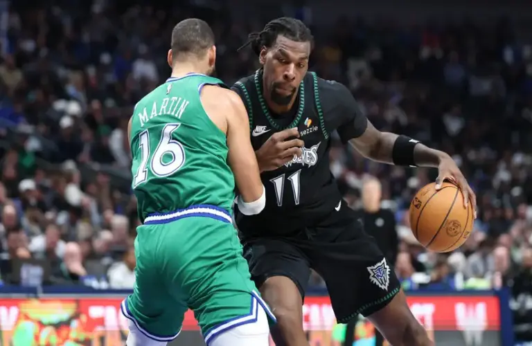 Timberwolves center Naz Reid (11) drives against Mavericks forward Caleb Martin (16).