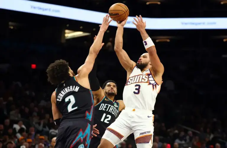 Detroit Pistons guard Cade Cunningham (2) and forward Tobias Harris (12) defend against Phoenix Suns forward Dillon Brooks (3) in the first half.