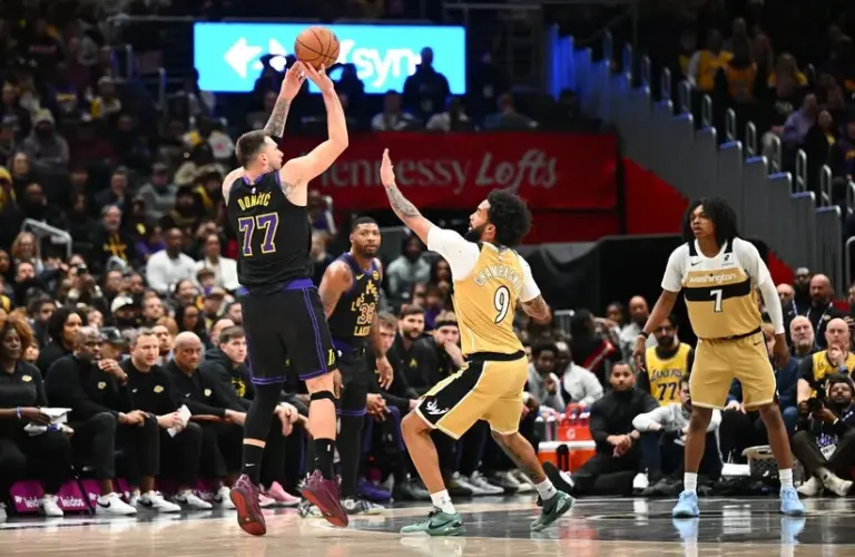 Los Angeles Lakers forward/guard Luka Doncic (77) shoots over Washington Wizards guard/forward Justin Champagnie (9) during the first half at Capital One Arena