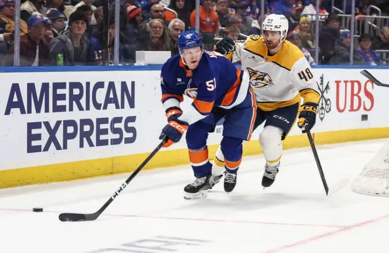 New York Islanders left wing Emil Heineman (51) and Nashville Predators defenseman Nick Perbix (48) battle for control of the puck in the second period at UBS Arena
