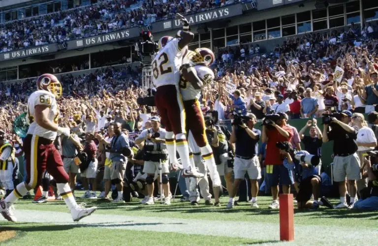 Washington Commanders receiver Michael Westbrook (82) and running back Stephen Davis (48) celebrate a touchdown against the Dallas Cowboys at RFK Stadium