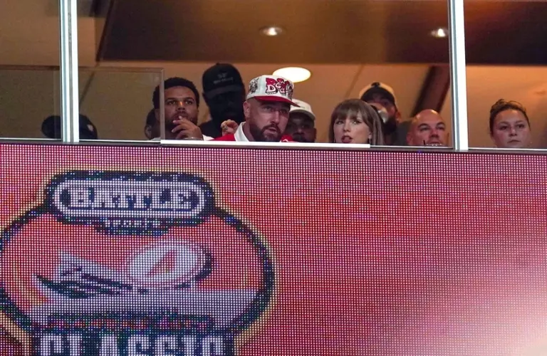 Taylor Swift looks on with Travis Kelce.