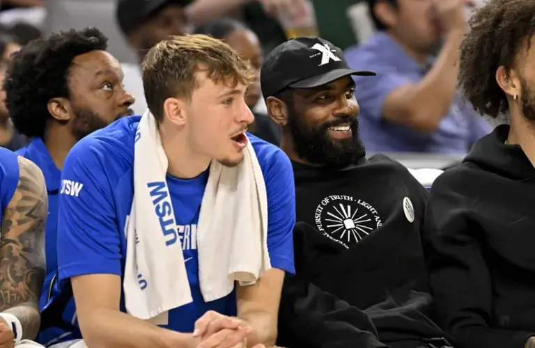 Dallas Mavericks forward Cooper Flagg (left) and guard Kyrie Irving (right) watch the game