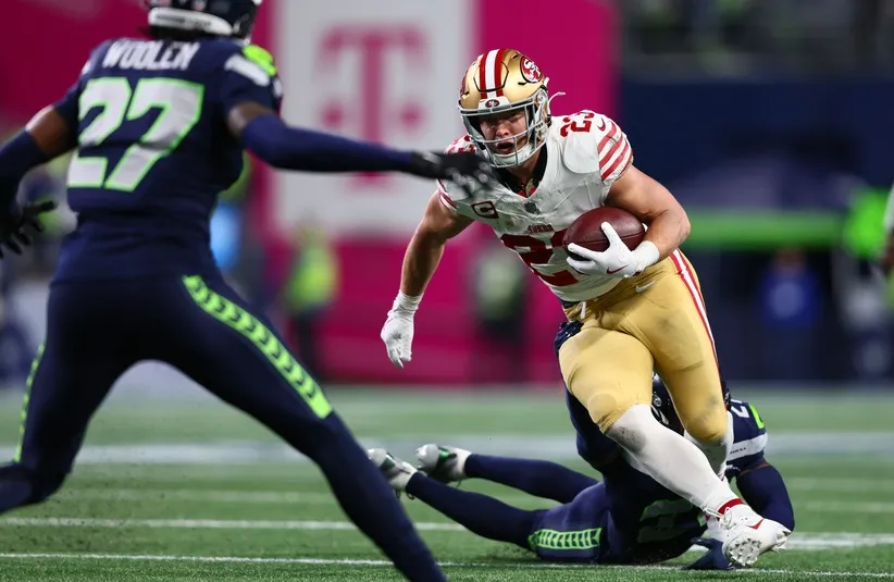 San Francisco 49ers running back Christian McCaffrey (23) carries the ball as Seattle Seahawks cornerback Devon Witherspoon (21)