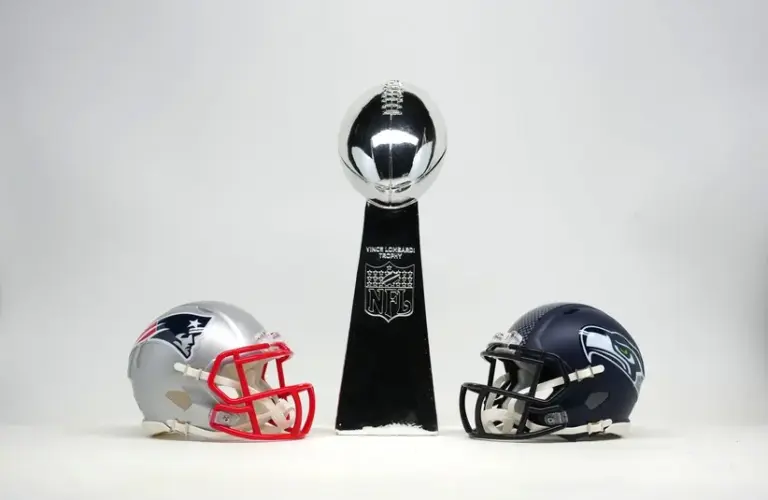 New England Patriots and Seattle Seahawks helmets with Super Bowl Vince Lombardi trophy.