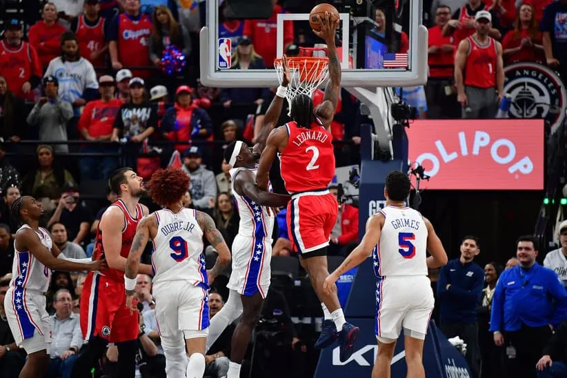 Feb 2, 2026; Inglewood, California, USA; Los Angeles Clippers forward Kawhi Leonard (2) dunks for the basket against Philadelphia 76ers center Adem Bona (30) during the second half at Intuit Dome.