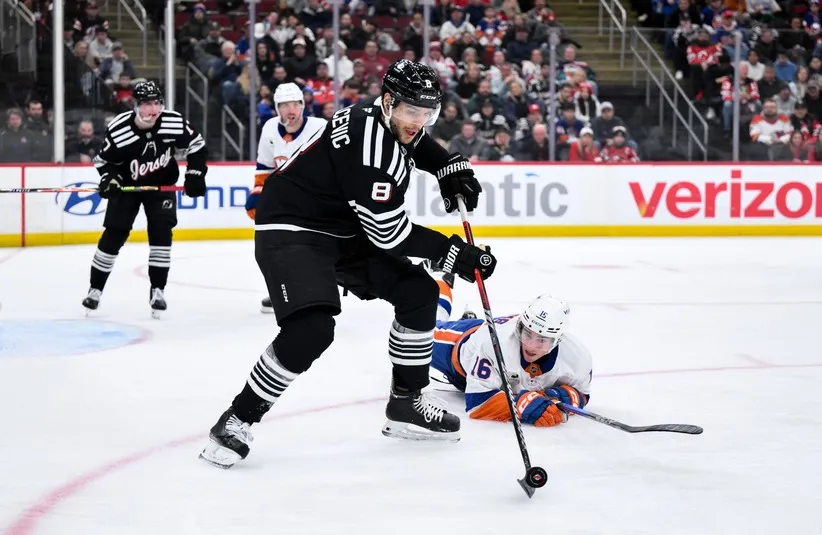 New Jersey Devils defenseman Johnathan Kovacevic (8) controls the puck against New York Islanders center Marc Gatcomb (16)