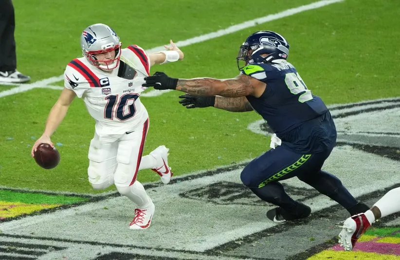 New England Patriots quarterback Drake Maye (10) is pressured by Seattle Seahawks defensive tackle Byron Murphy II (91) in the second half in Super Bowl LX at Levi's Stadium.