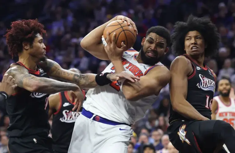 New York Knicks center Karl-Anthony Towns (32) drives against Philadelphia 76ers guard Kelly Oubre Jr. (9) and forward Marjon Beauchamp (16)