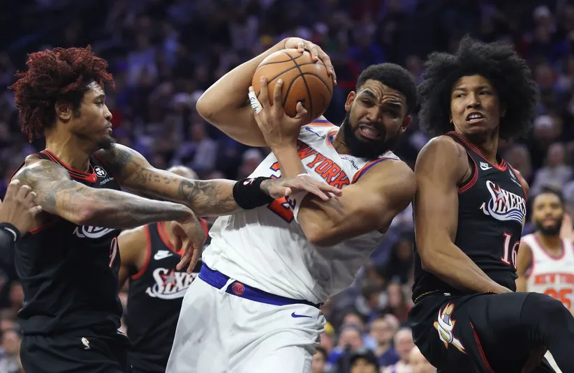 New York Knicks center Karl-Anthony Towns (32) drives against Philadelphia 76ers guard Kelly Oubre Jr. (9) and forward Marjon Beauchamp (16)