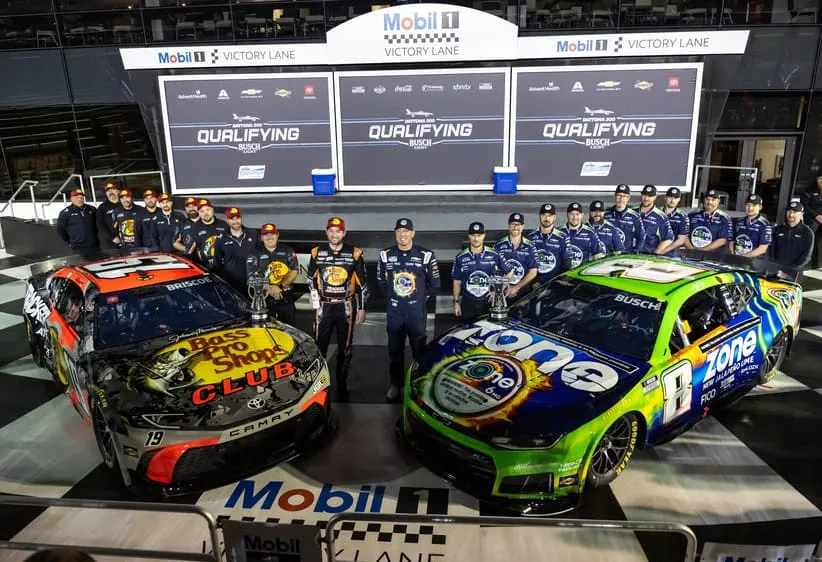 Feb 11, 2026; Daytona Beach, Florida, USA; NASCAR Cup Series driver Kyle Busch (8) and Chase Briscoe (19) and crew celebrate after securing the front row during qualifying for the Daytona 500 at Daytona International Speedway.