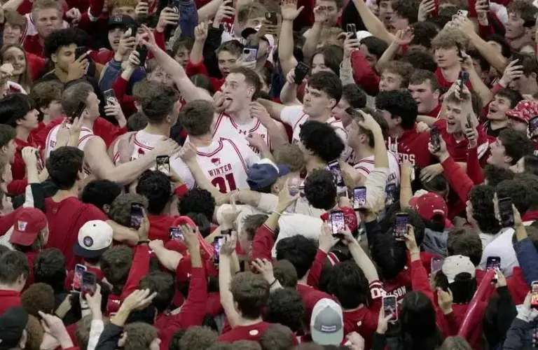 Wisconsin forward Austin Rapp (tongue wagging) and his teammates are swarmed by fans after their game Friday, February 13, 2026 at the Kohler Center in Madison, Wisconsin. Wisconsin beat 10th ranked Michigan State 92-71.