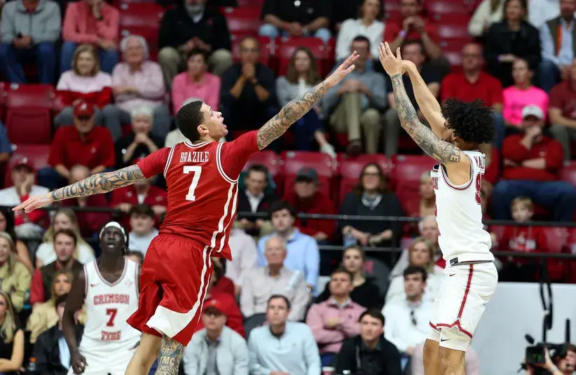 Arkansas Razorback forward Trevon Brazile (7) tries to block Alabama Crimson Tide guard Houston Mallette (95) during the first half.
