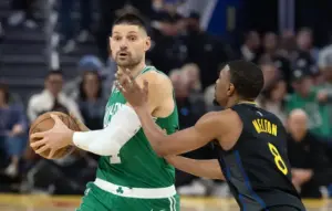 Boston Celtics center Nikola Vucevic (4) looks to pass around Golden State Warriors guard De'Anthony Melton (8) during the first quarter.