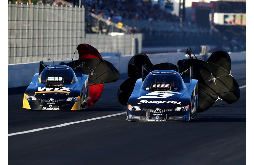 Nov 8, 2013; Pomona, CA, USA; NHRA funny car driver Tony Pedregon (left) races alongside brother Cruz Pedregon during qualifying for the Auto Club Finals at Auto Club Raceway at Pomona. Mandatory Credit: Mark J. Rebilas-Imagn Images