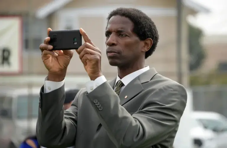 NBA former player A.C. Green takes photos with a cell phone