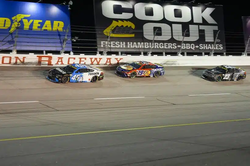 Aug 31, 2025; Darlington, South Carolina, USA; NASCAR Cup Series driver Tyler Reddick (45) and driver Chase Briscoe (19) race into turn two during the Cookouts Southern 500 at Darlington Raceway.