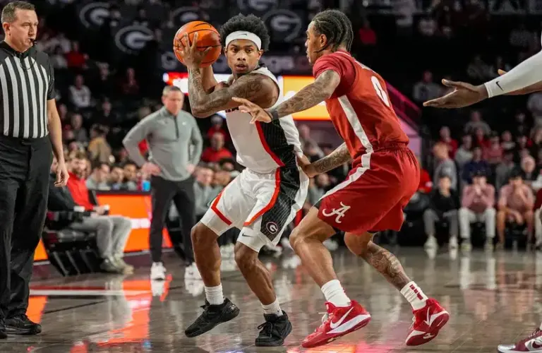 Georgia Bulldogs guard Marcus Millender (4) controls the ball against Alabama Crimson Tide guard Labaron Philon (0) during the first half.