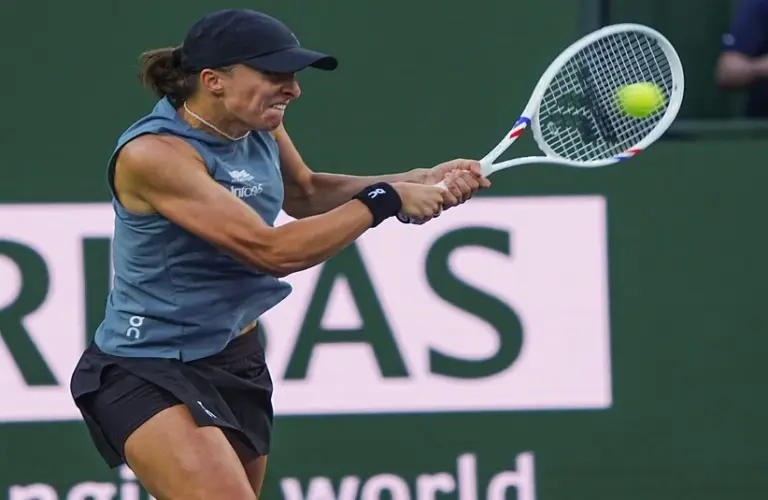 Świątek hitting a backhand