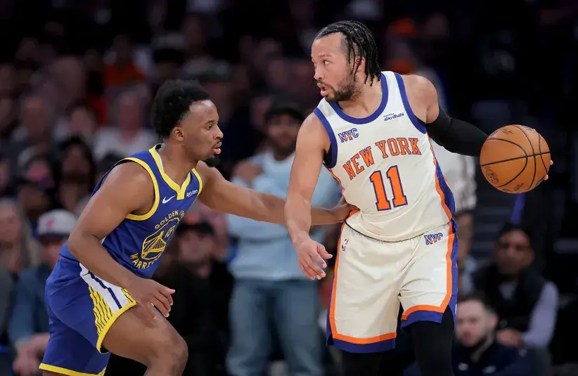 New York Knicks guard Jalen Brunson (11) controls the ball against Golden State Warriors guard Lj Cryer (18) during the first quarter at Madison Square Garden.